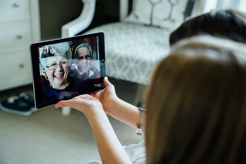 Женщина разговаривает по видеосвязи на планшете бабушки и дедушки